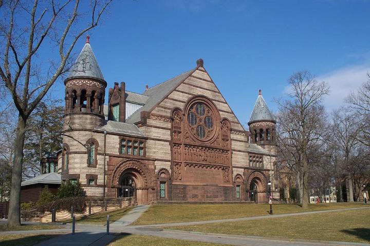 a large brick building with grass in front of a church